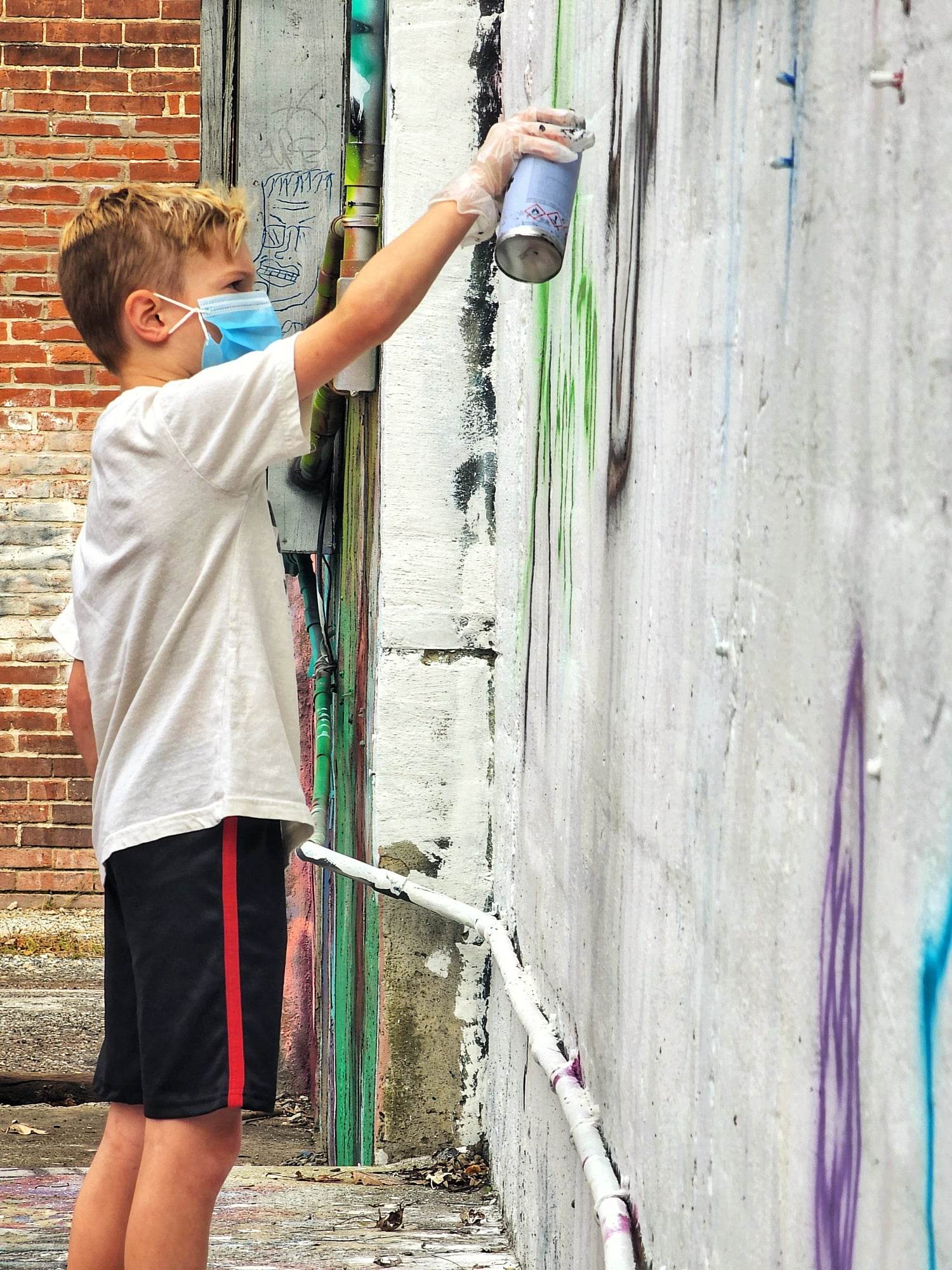 ruins young boy spray painting